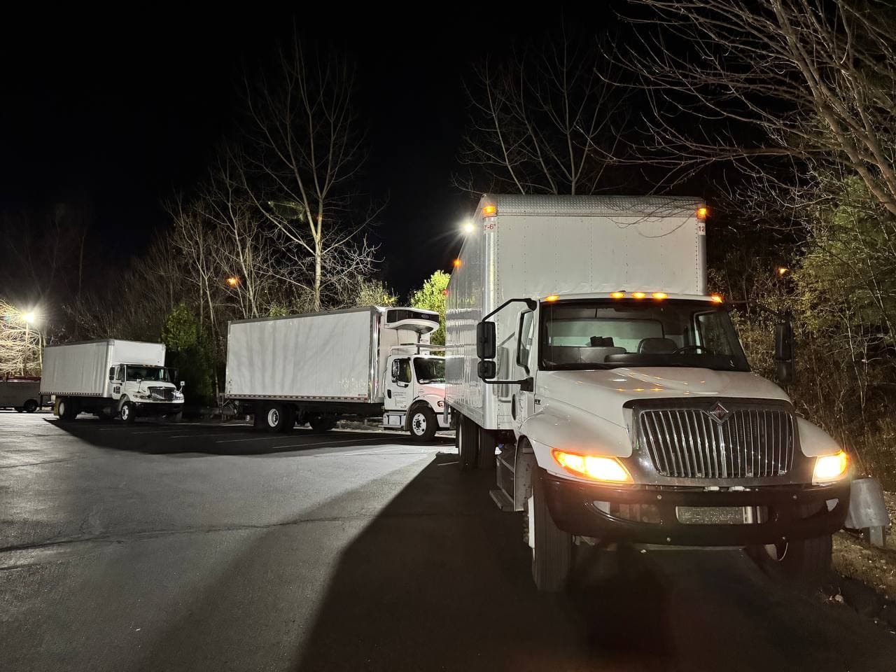 Global 3Xpress fleet — three box trucks lined up at night